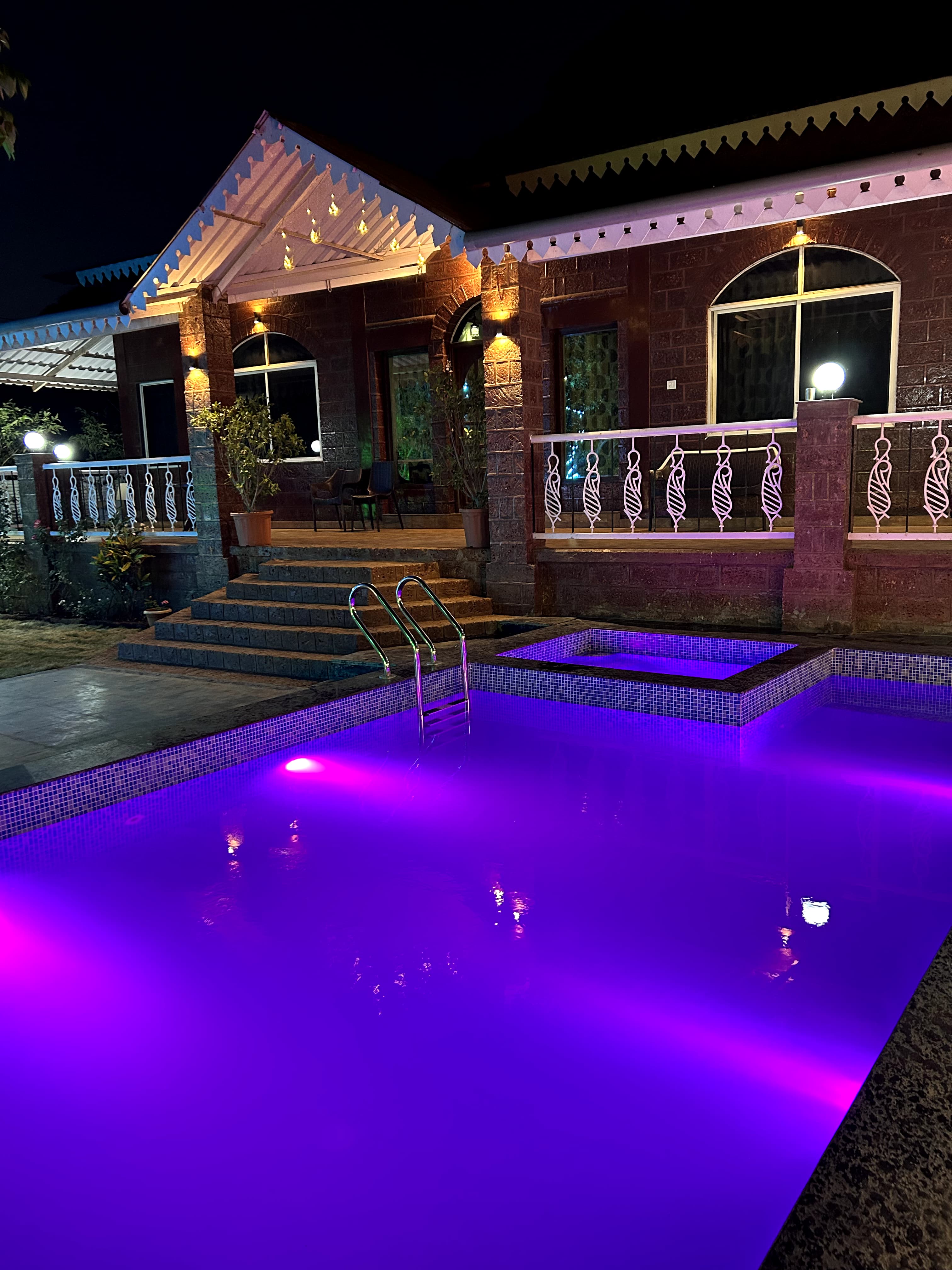 Private pool with bungalow lights at night